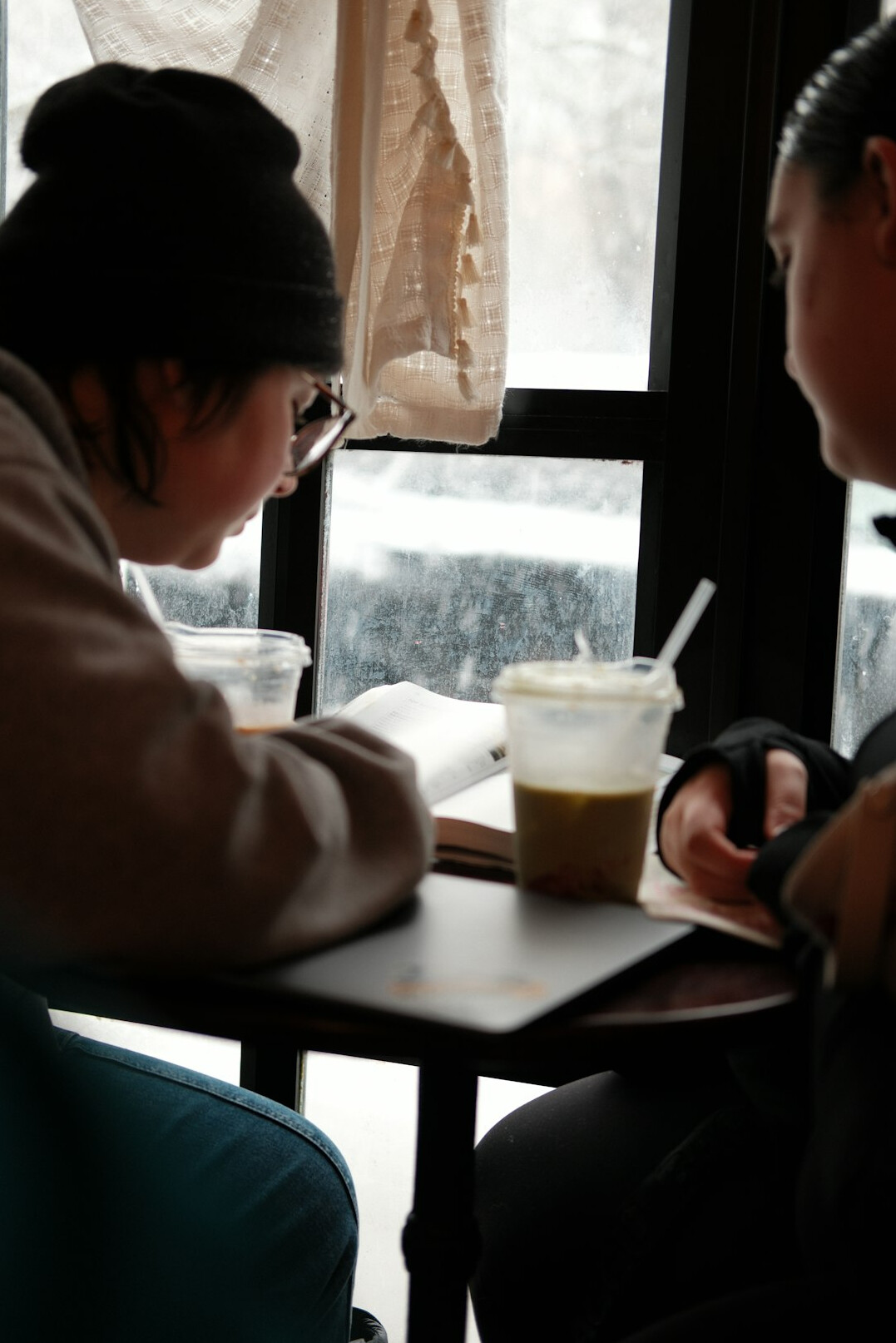 person reading book by window